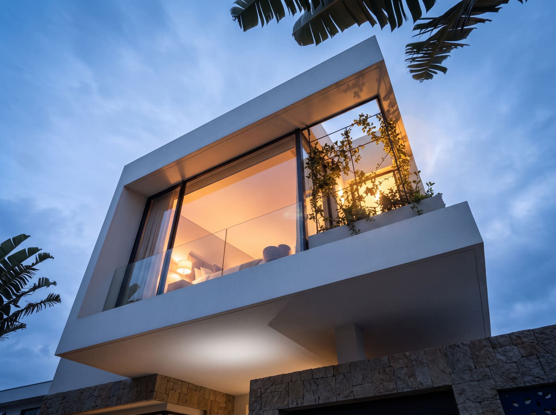 Chambre vitrée en porte-à-faux éclairée au crépuscule
